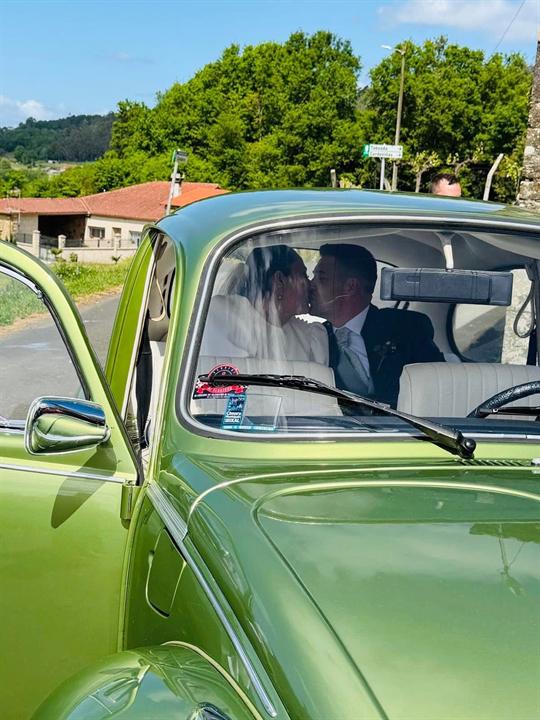 Beso de los novios dentro del coche clásico