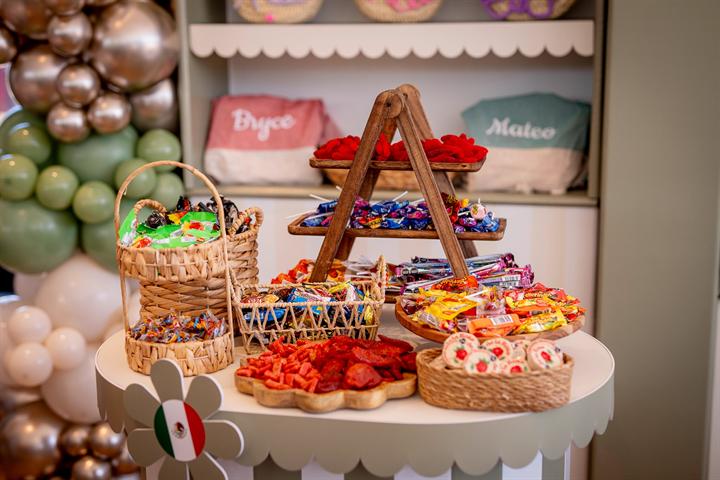Mesa de chuches con globos verdes y plateados